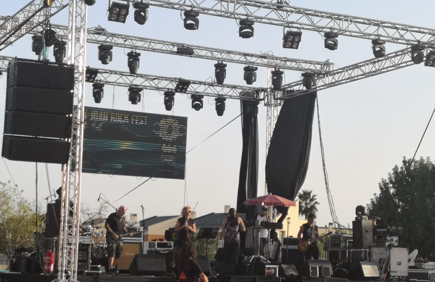 Escenario iluminado con equipo de sonido durante un evento musical
