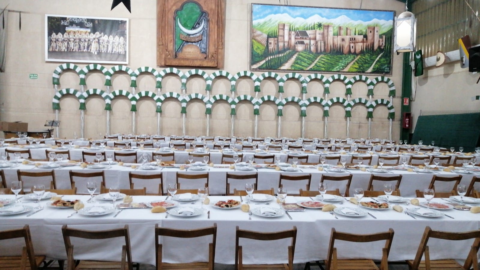 Filas de mesas preparadas con vajilla para evento
