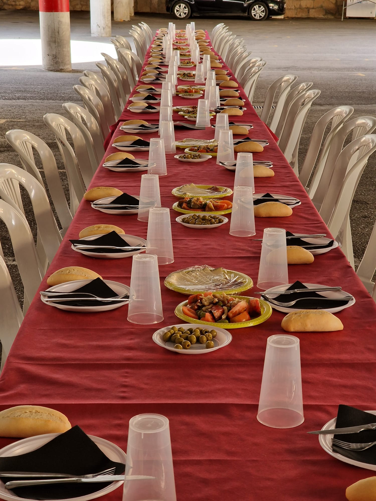 Mesa larga con comida y montaje para catering en celebración popular